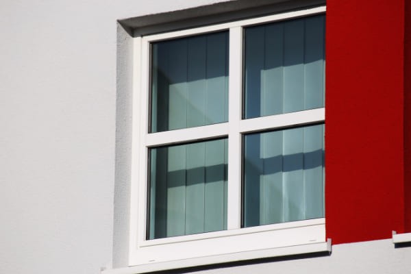 Fenster mit Sprossen in roter Fassade